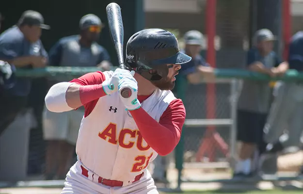 Baseball Playoff Bid Comes Up Short - Arizona Christian University Baseball batter in a white and red uniform wearing a helmet, swinging a bat during a game with spectators in the background.
