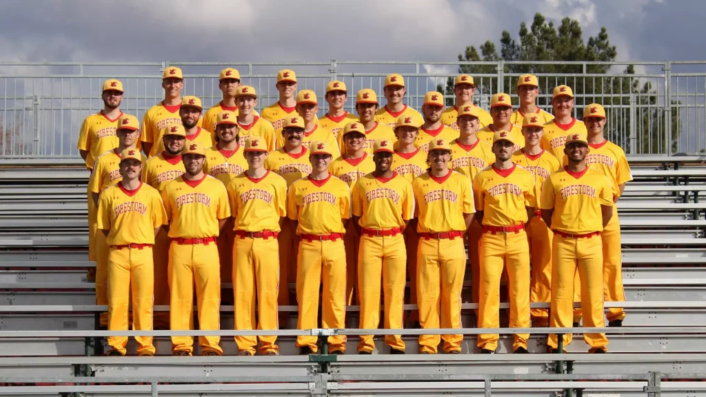 Firestorm baseball team posing on metal bleachers in bright yellow uniforms outdoors, group photo