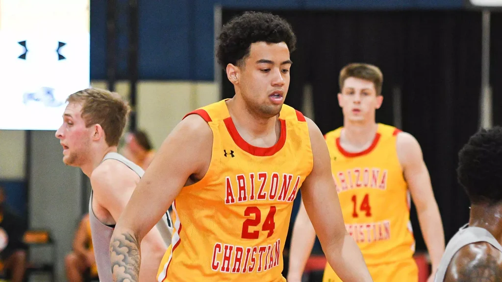 Basketball player in orange Arizona Christian jersey #24 dribbling on court during game, teammate behind in yellow jersey #14 in background.