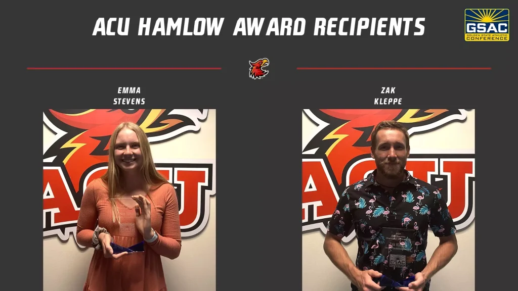 Two award recipients stand in front of a dark backdrop with red lines and a logo, each holding a trophy. The woman on the left wears a peach dress; the man on the right wears a floral shirt.