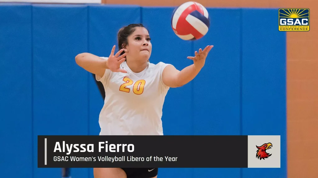 Volleyball player in a white jersey #20 reaches for a ball in a gym with blue walls; GSAC logo in the top-right corner.